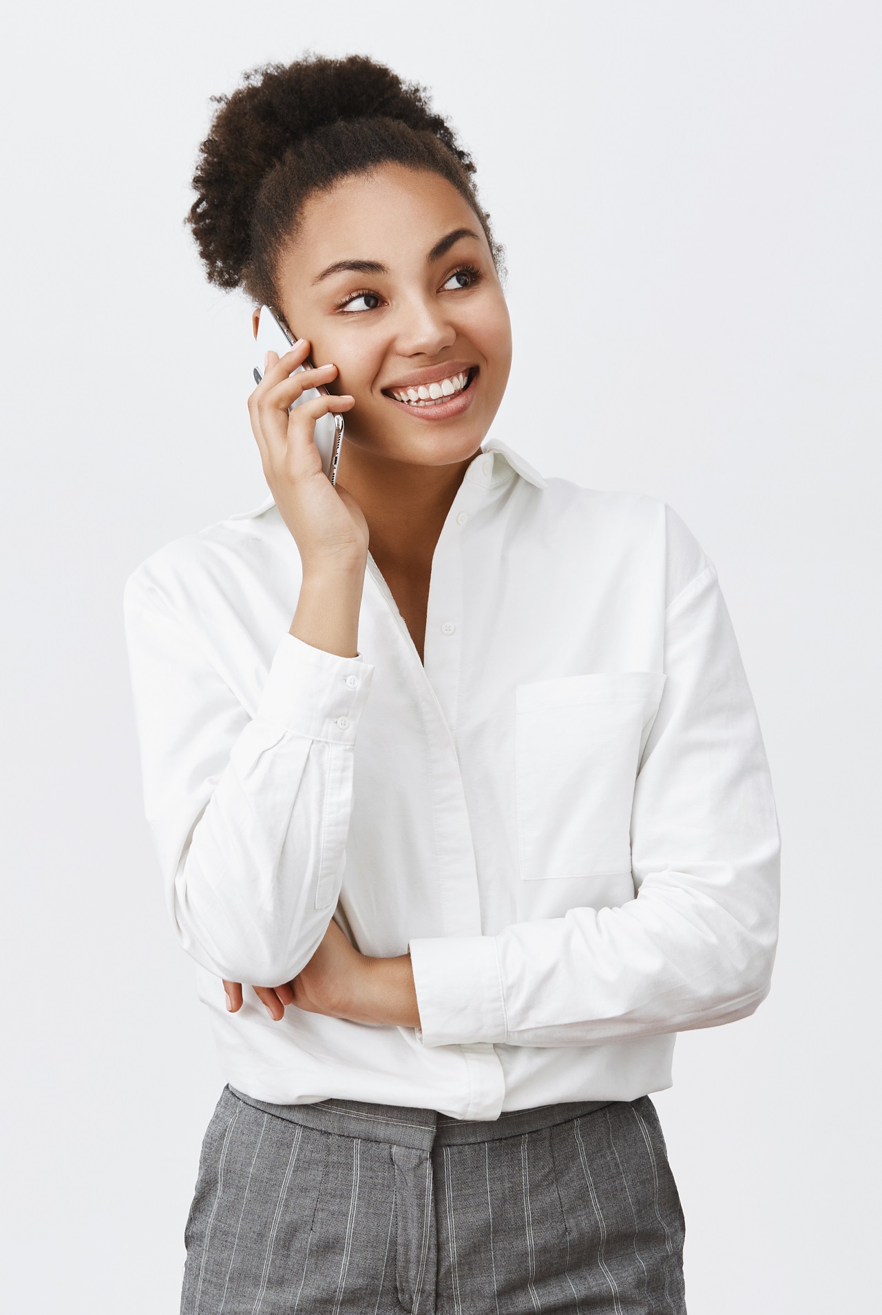 Hungry coworker calling food delivery to come quickly. Charming happy and confident creative female boss in shirt and pants, talking via smartphone, gazing aside, having interesting conversation